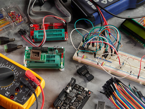 Programmers and Arduino with peripherals and expansion boards lie on a gray background.