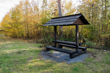 Empty wooden picnic canopy with sitting in autumn nature