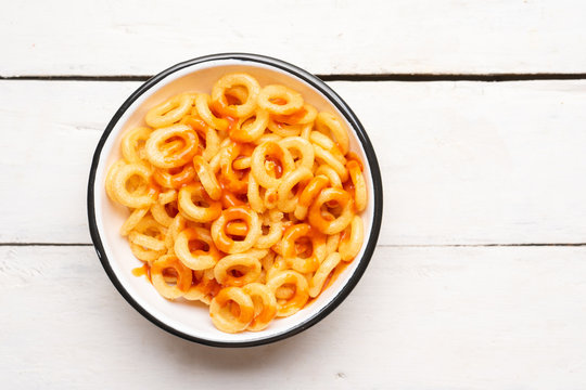 Rings of fried wheat with piquant sauce is a mexican snack on white background