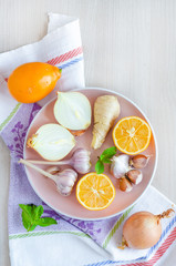 top view, vertical set of vegetables garlic, ginger, onions, lemon to boost immunity, treat colds, viruses, flu on light background with copy space. alternative to pills, drugs