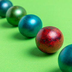 Colorful easter eggs in a row on a light green background