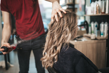 Beautiful hairstyle of woman after dyeing hair and making highlights in hair salon.
