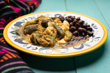 Mexican poblano pepper rajas and panela cheese on turquoise background