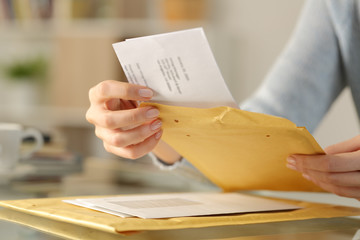 Woman hands opening a padded envelope on a desk