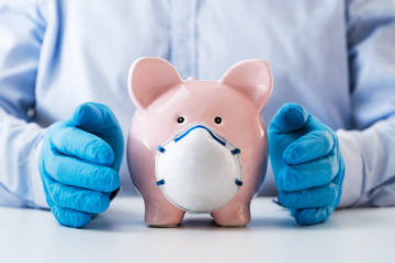 Human Hand Protecting Piggy Bank