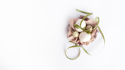Easter nest with eggs and green ribbon on white background. Eco style easter. Flatlay