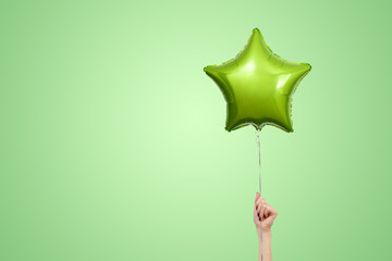 Light green birthday balloons with copy space for text. star shaped balloon isolated on green...