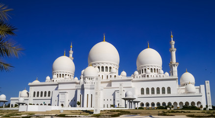 Fototapeta na wymiar Outside view of the marble domes and the minaret of Sheikh Zayed Mosque in Abu Dhabi
