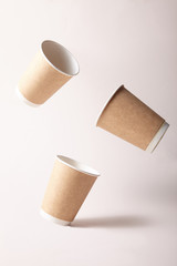 three 3 Levitating organic paper cup wood for concept of zero waste dinnerware on brown background	