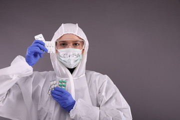 Doctor in protective costume holds a syringe against coronavirus