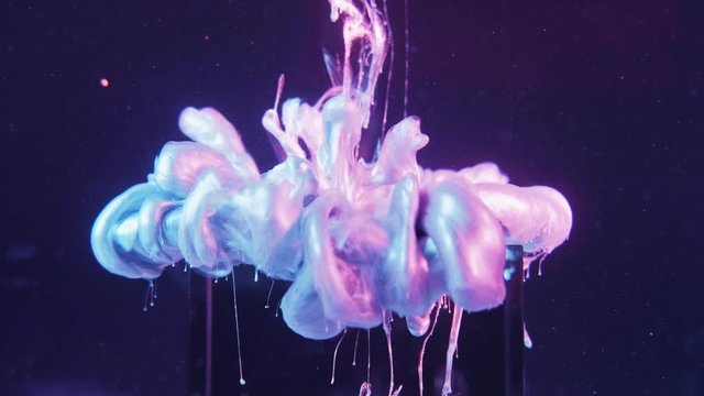Fluid splash. Dreamlike eternity. Pearl paint shot over glass cube on grape compote purple background.