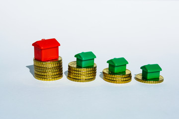 red and green house made of coins isolated on white