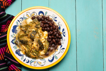 Mexican poblano pepper rajas and panela cheese on turquoise background
