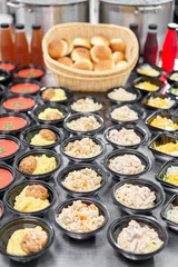 Row of plastic disposable lunch box with healthy natural food. Soups, cream soup, main course with side dish, salads. Food delivery. Lunch in the office.