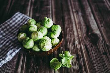 Choux de Bruxelles crus dans un bol en bois posé sur la table de cuisine