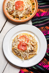 Mexican salbutes with shredded chicken on white background
