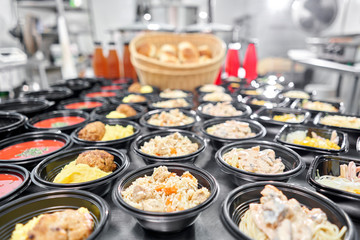 Row of plastic disposable lunch box with healthy natural food. Soups, cream soup, main course with side dish, salads. Food delivery. Lunch in the office.