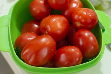 Fresh colorful red tomatoes in a green container