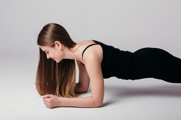 The trainer shows the correct push-ups. A girl stands in the bar for a set of exercises