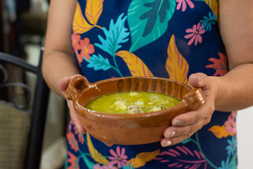Unrecognizable Woman with a Mexican dish pozole.