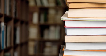 The stack ancient books on a library background