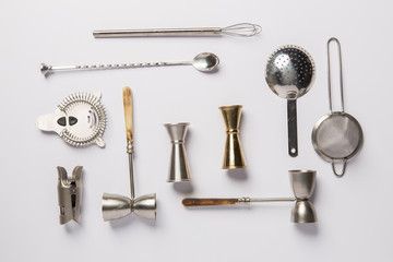 Flat lay composition with bartender iron tools, such as cocktail shaker, jigger, mixing glass,...