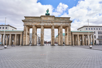 Fototapeta premium berlin, niemcy, widok na słynną Bramę Brandenburską na placu 10 Maja w Berlinie, plac paryski bez turystów i gości - bezludne, błękitne niebo, małe chmurki