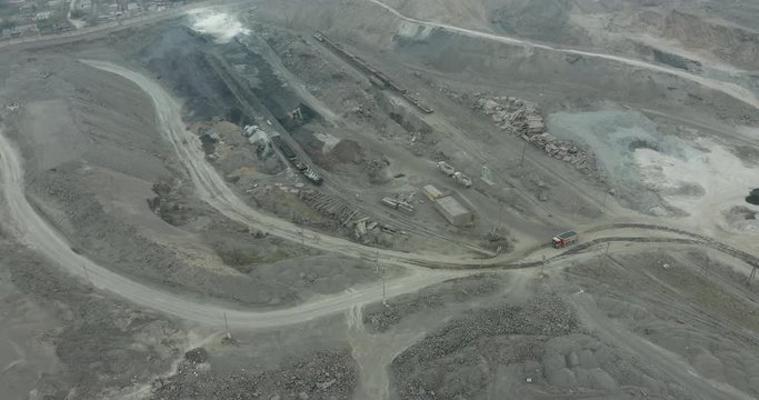 Heavy equipment digs and hauls ore inside an enormus open pit mine.