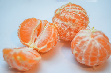 Tangerines or clementines with green leaf on white background. Peeled tangerine or mandarin fruit isolated
