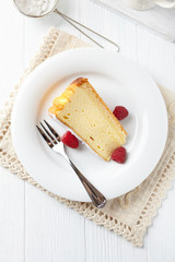  Piece of cheese cake on bright background. Bright wooden background. Top view.
