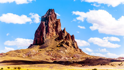 The rugged peaks of El Capitan and Agathla Peak towering over the desert landscape south of Monument Valley along Highway US Route 163 in northern Arizona, United States