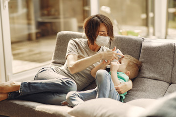 Family stay at home. Mother with little son. Coronavirus theme. Mom measures baby's temperature.