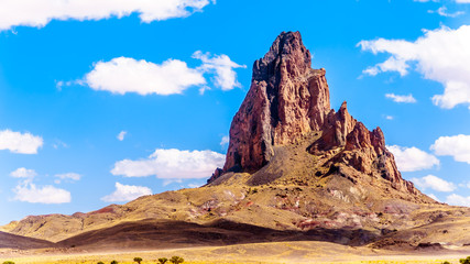 The rugged peaks of El Capitan and Agathla Peak towering over the desert landscape south of Monument Valley along Highway US Route 163 in northern Arizona, United States