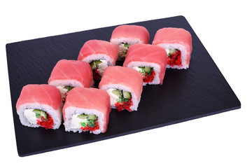 Traditional fresh japanese sushi rolls on a black stone Red Dragon on a white background. Roll ingredients: tuna, philadelphia cheese, cucumber, hiyashi wakame seaweed, red tobika, nori, rice.