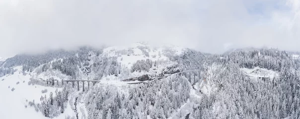 Foto op Plexiglas Landwasserviaduct Luchtfoto van het Landwasser-viaduct met spoorlijn zonder beroemde trein in de winter, oriëntatiepunt van Zwitserland, sneeuw, rivier en bergen