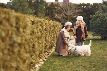 Family in a garden. Mother with daughter. People with little dog.