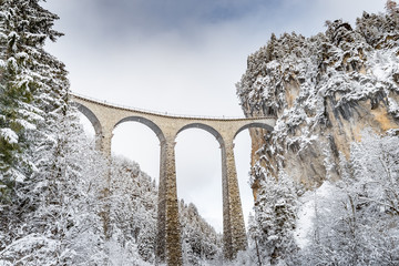 Het Landwasser-viaduct met spoorweg zonder beroemde trein in de winter, oriëntatiepunt van Zwitserland, sneeuw, rivier en bergen