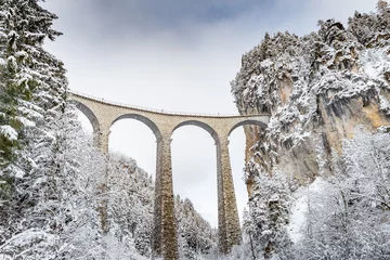 Fotobehang Landwasserviaduct Het Landwasser-viaduct met spoorweg zonder beroemde trein in de winter, oriëntatiepunt van Zwitserland, sneeuw, rivier en bergen