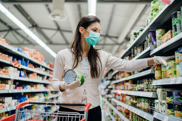 Woman preparing for pathogen virus pandemic spread quarantine.Choosing nonperishable food...