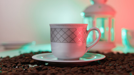 Coffee beans are scattered on the table. Coffee Cup with beans. Still life with a Cup and a lantern. Beautiful coffee beans. Natural still life .