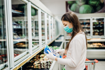 Woman wearing face mask buying in supermarket.Panic shopping during Coronavirus covid-19...