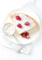 Piece of cheese cake on bright background. Bright wooden background. Top view.