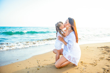 Gentle hugs and a kiss on the sea. Loving mother and daughter on the sea coast, happy family