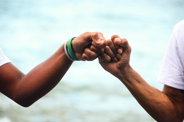 Two friends joining their fists as a prove of friendship.