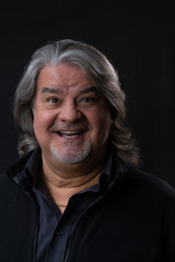 Studio head shot of man while he is smiling and looking to the camera.