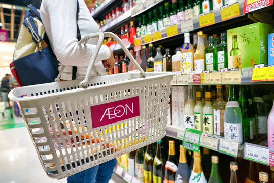 SHENZHEN, CHINA - CIRCA APRIL, 2019: woman with basket shopping for drinks at JUSCO store in Shenzhen.