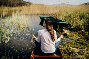 Woman meditating in nature.Escape from stressful reality.Mindful woman practicing meditation.Breathing technique.Mental state issues menagement.Imagination.Traveling with mind.Focus on healing.Stress