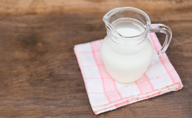 Fresh milk natural in a glass jug on wooden table - Serving breakfast milk concept