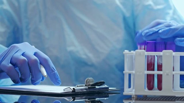 MERS-CoV infection. Microbiology research. Nurse in gloves recording blood test results.