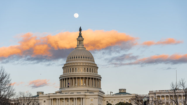 Washington Capitol at sunset with the moon behing it.
